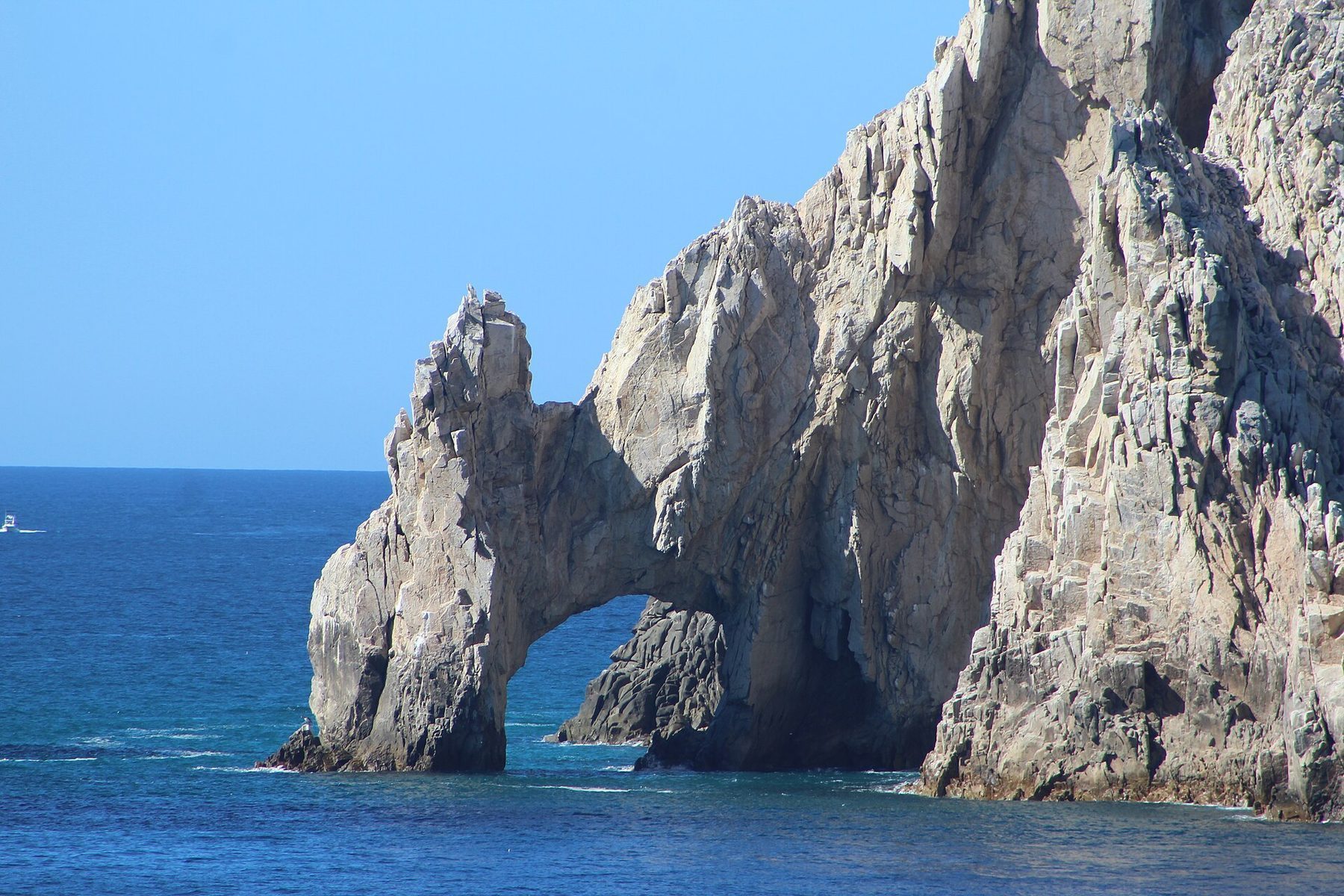 Aerial view of the Arch of Cabo San Lucas where the Pacific meets the Sea of Cortez during calm summer weather
