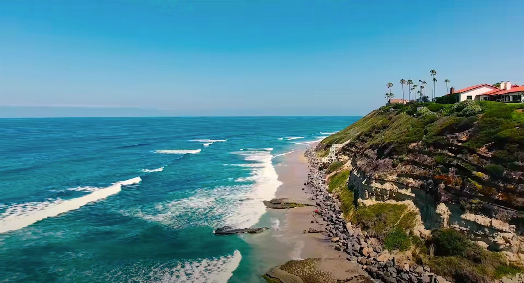 Aerial view of Pedregal de Cabo San Lucas showing Mediterranean villas built into Pacific cliffside above the marina