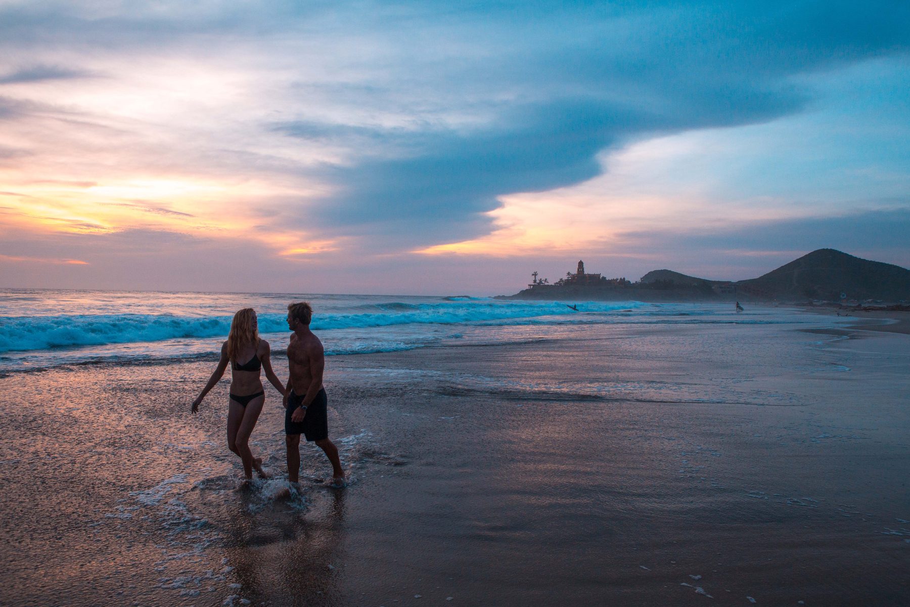Couple walking on a Los Cabos beach as part of an active outdoor lifestyle